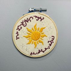 an embroidered sun is hanging on the wall