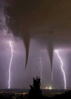 lightning strikes over the city at night time