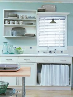 the kitchen is clean and ready to be used for cooking or baking, with dishes on shelves above the sink