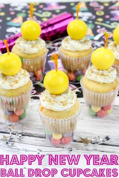 some cupcakes with yellow and white frosting on top are sitting on a table