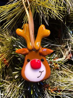 an ornament hanging from a christmas tree with a red nose and nose on it