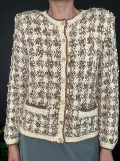 a woman is wearing a brown and white cardigan