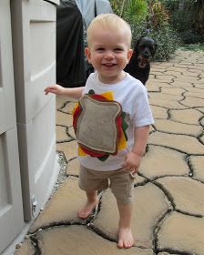 a little boy standing in front of a door with a stuffed animal on his chest