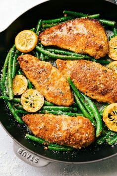 chicken and green beans in a skillet with lemon slices