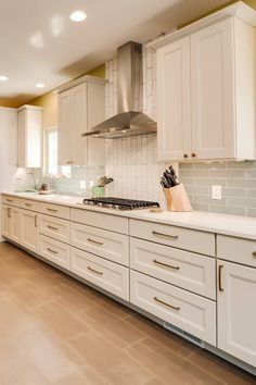 a kitchen with white cabinets and counter tops