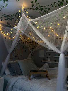 a canopy bed with lights hanging from the ceiling