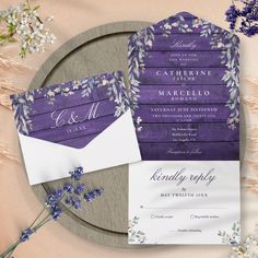 the wedding stationery is purple and white, with lavender flowers on each card sleeve