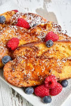 french toast with berries and powdered sugar on a plate