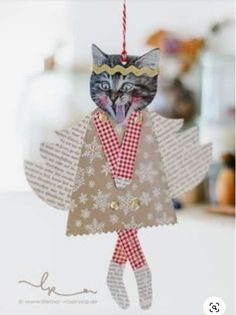 an ornament made to look like a cat wearing a coat and tie with snowflakes on it