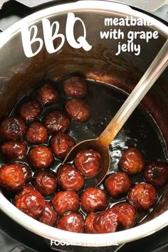 the meatballs are being cooked in the crock pot with a wooden ladle