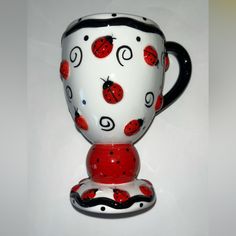 a red and white coffee cup with ladybugs on it