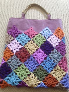 a crocheted purse sitting on top of a carpet