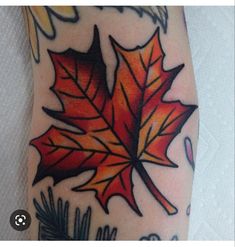 a tattoo with an orange and red leaf on it