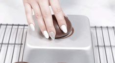 a woman's hand with white nail polish on top of a computer mouse pad