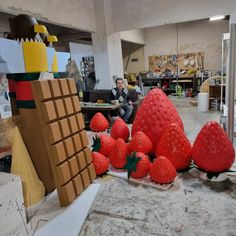 some strawberries are laying on the ground in front of a man sitting at a table