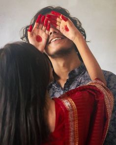 a man covering his eyes with hands while standing next to a woman's face