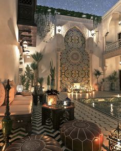 the interior of an ornately decorated building with candles lit up on tables and stools