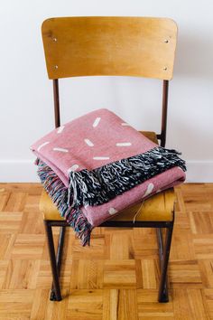 a stack of blankets sitting on top of a wooden chair