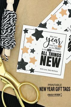 a pair of scissors next to some new year's tags