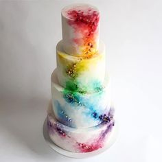 a multi - tiered cake with colorful icing and sprinkles on it