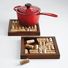 a red pot and pan with corks in it sitting on top of a wooden tray