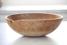 a wooden bowl sitting on top of a table