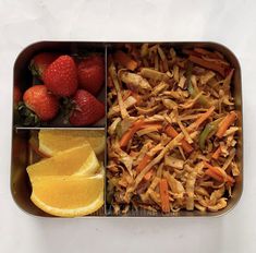 a metal container filled with fruit and veggies on top of a white table