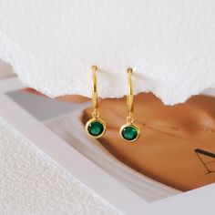 Add a touch of vibrant elegance to your jewelry collection with these Dainty Emerald Huggie Earrings. Featuring tiny emerald stones set in high-quality sterling silver, these hoops offer a rich green hue that symbolizes renewal and growth, making them perfect as a birthstone gift for those born in May or for anyone who loves the timeless beauty of emeralds. The dainty, huggie-style design ensures a comfortable fit, ideal for everyday wear or special occasions. Whether as a thoughtful gift for he Green Tarnish-resistant Huggie Jewelry, Elegant Green Dangle Huggie Earrings, Elegant Green Huggie Jewelry, May Birthstone Round Hoop Earrings For Pierced Ears, Hoop Earrings For Anniversary With May Birthstone, May Birthstone Round Hoop Earrings, Anniversary Hoop Earrings With May Birthstone, Elegant Green Huggie Hoop Earrings, Elegant Green Hoop Huggie Earrings