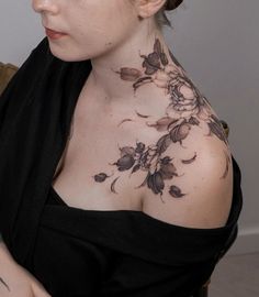 a woman with tattoos on her chest wearing a black dress