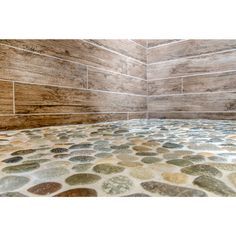 an image of a bathroom setting with stone flooring and wood paneled shower walls