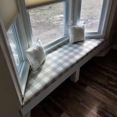 a window seat with two pillows on it