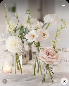 three glass vases with flowers in them on a white table cloth covered tablecloth