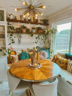 a dining room table surrounded by chairs and plants