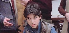 a young boy sitting in front of a group of people