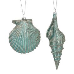 two sea shells hanging from chains on a white background