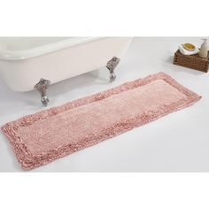 a bathroom with a pink rug and bathtub