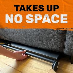 there is a sign that says it takes up no space on the floor next to a couch