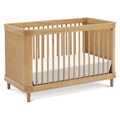 a wooden crib with white sheets on the bottom and sides, in front of a white background