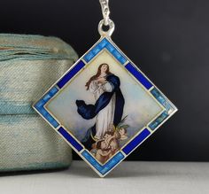 A genuine vintage German Virgin Mary medal, antique enamel charm, very nicely done, in good vintage condition, ideal for a protection necklace, would make a nice gift for someone special! Medal floats from a 22-inch long vintage 925 silver chain! Material: solid silver, enamel Weight (with chain): 10.4g Measures: approx. 30 x 35 mm  PLEASE LOOK AT THE PICTURES, THEY ARE PART OF THE DESCRIPTION AND ARE THE ACTUAL ITEM YOU WILL RECEIVE.  ALL OUR ITEMS ARE IN WORN, VINTAGE CONDITION. Antique Enamel Necklace Hallmarked, Antique Enamel Necklace With Hallmark, Antique Enamel Hallmarked Necklaces, Antique Engraved Enamel Necklace, Victorian Engraved Enamel Necklaces, Vintage Blue Enamel Necklace, Vintage Miraculous Medal Necklace As Gift, Vintage Miraculous Medal Necklace Gift, Antique Miraculous Medal Necklace As Gift