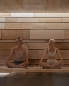 an older man and woman are sitting in a sauna