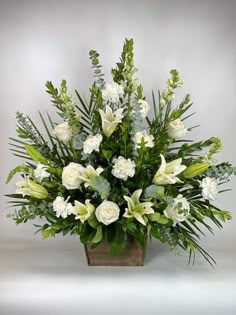 white flowers and greenery in a wooden vase