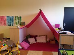 a child's playroom with a pink tent and lots of toys on the floor