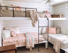 a bedroom with bunk beds and pink blankets on top of the bed, next to a window