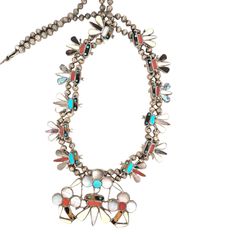 The High Plains squash blossom necklace is a rare vintage treasure, handcrafted by Native American artisan Sensa Eustace. Featuring an intricate bee motif, this sterling silver necklace showcases 12 smaller bees (1" tall each) and a larger central bee surrounded by floral accents. The inlay work includes turquoise, coral, mother of pearl, abalone shell, and bone, creating a vibrant and unique design. Signed and dated "Sensa Eustace, Zuni New Mex. 8/4/93," this 26" long necklace with a 3.5" naja centerpiece is a one-of-a-kind statement piece. Vintage Native American handmade squash blossom necklace. Sterling silver with intricate bee motif and floral accents. Inlaid with turquoise, coral, mother of pearl, abalone shell, and bone. Signed "Sensa Eustace, Zuni New Mex. 8/4/93" for authenticity Squash Blossom Necklace Sterling Silver Mounted, Silver Squash Blossom Necklace, Small Bees, Squash Blossom Necklace, Squash Blossom, Abalone Shell, Native American Jewelry, Sterling Silver Necklace, Shop Necklaces