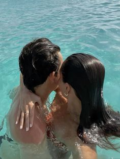 a man and woman kissing in the water