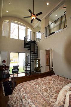 a bedroom with a spiral staircase leading to the second floor