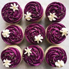 cupcakes with purple frosting and white flowers on them are displayed in an instagram