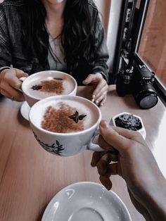 two people sitting at a table with bowls of food