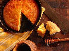 a cake in a pan with a slice cut out and honey comb next to it