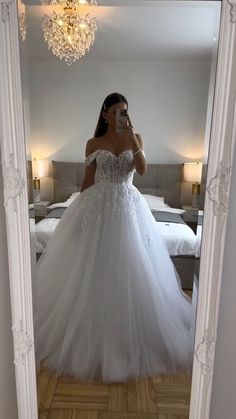 a woman taking a selfie in her wedding dress while standing in front of a mirror